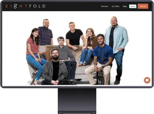 A photo of the Eightfold team posing ariund a couch